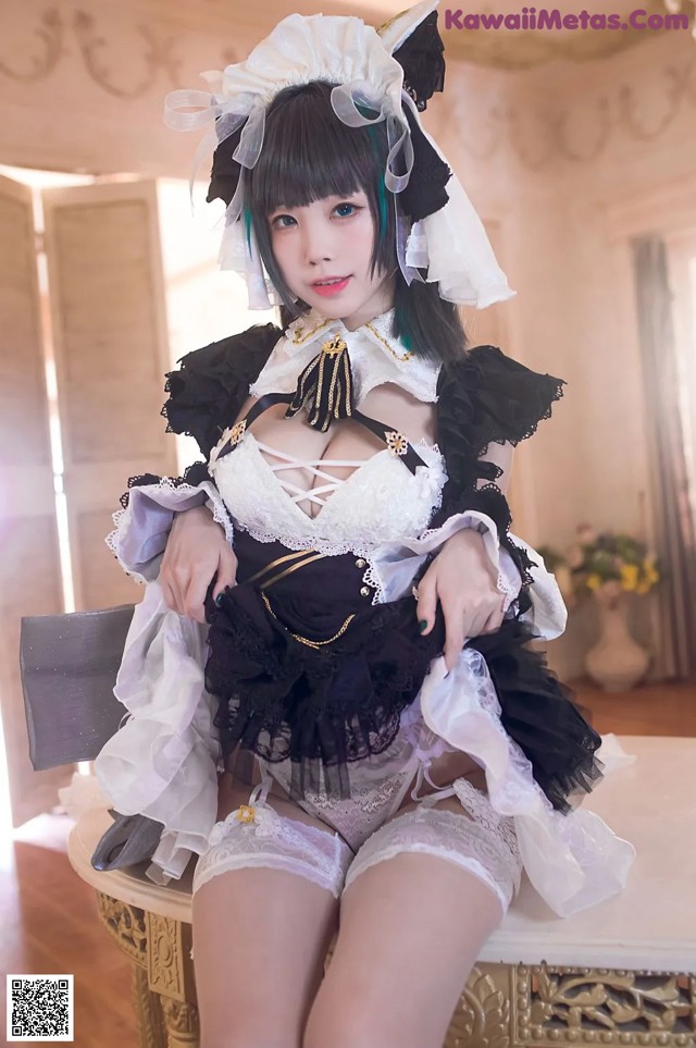 A woman in a maid outfit sitting on a chair.