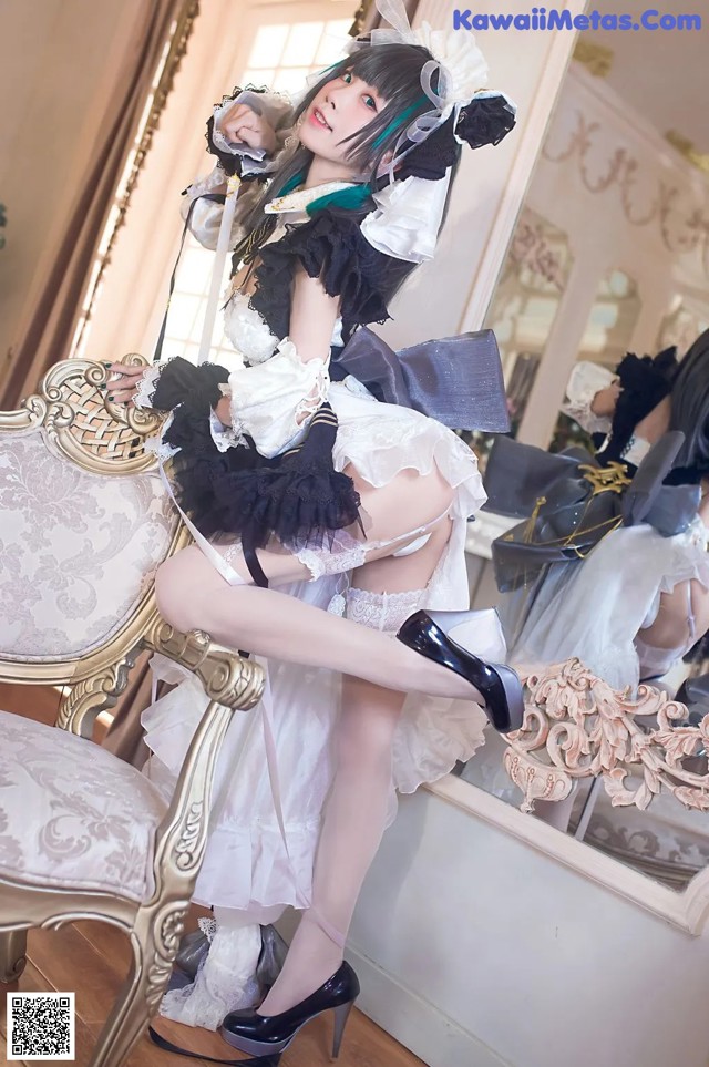 A woman in a maid outfit sitting on a chair.