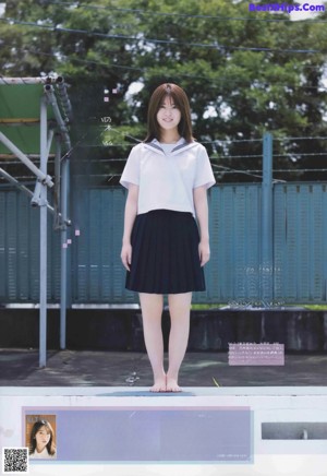 A woman in a school uniform holding a fishing rod.