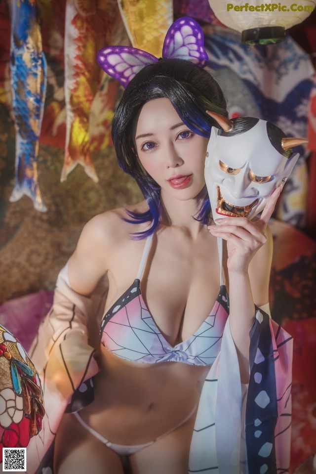 A woman in a bikini holding a mask in her hand.