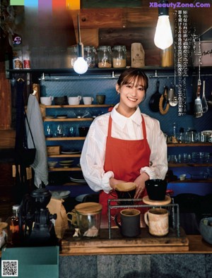 A woman sitting at a table with a cup of coffee.