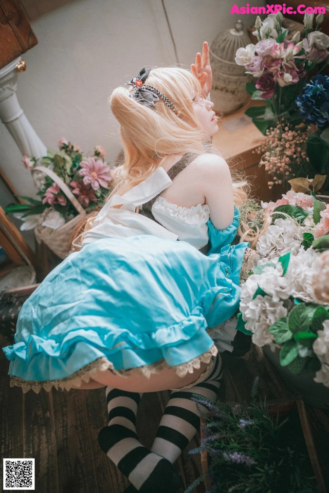 A woman sitting on the floor next to a bunch of flowers.