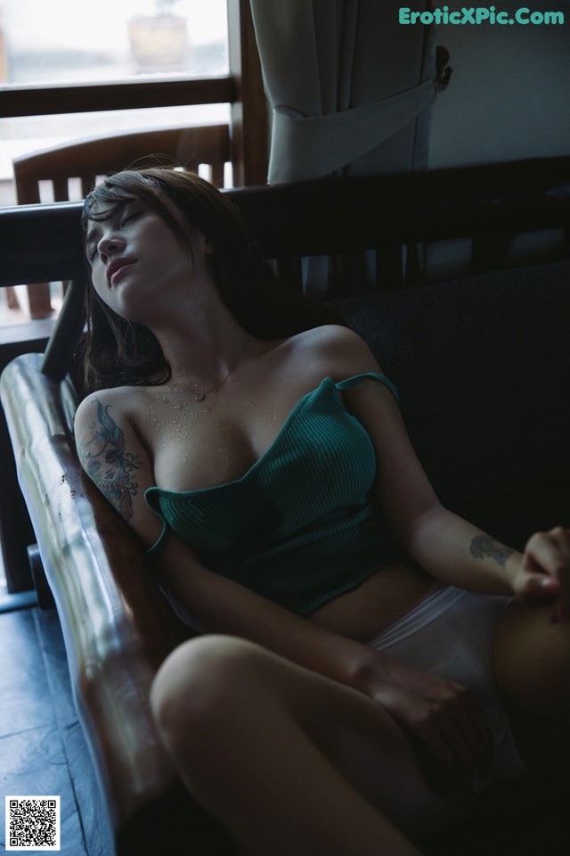 A woman sitting on a couch with her eyes closed.