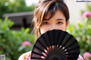 A woman in a kimono holding a fan.