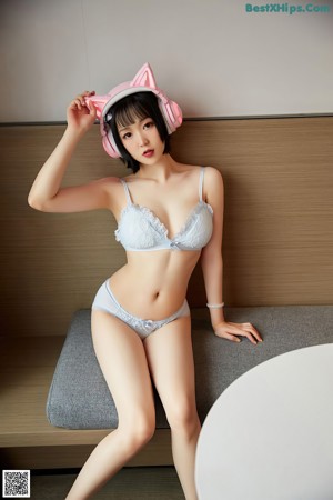 A naked asian woman wearing a pink cat ears headband.