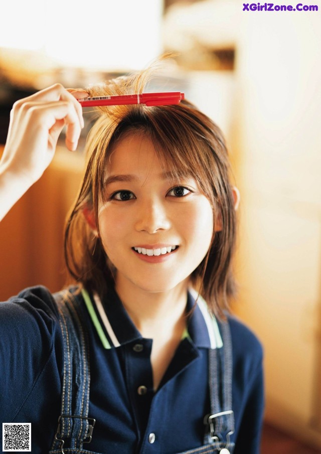 A young woman holding a red pen in her hand.