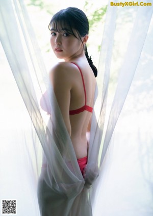 A woman in a red bathing suit is posing for a picture.