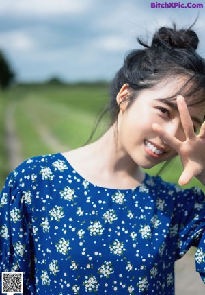 A woman in a white shirt is posing for a picture.