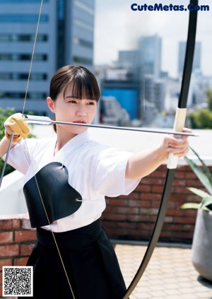 A woman in a yellow dress holding a blue umbrella.