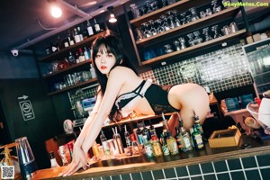 A woman in lingerie drinking from a glass.