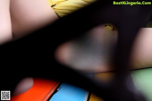 A naked woman sitting on top of a colorful bench.