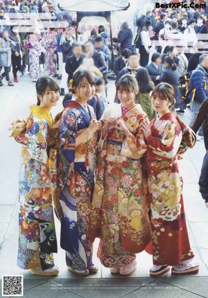 A group of women in kimonos standing on some steps.