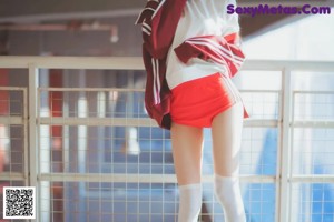 A woman in a school uniform crouching on the floor.