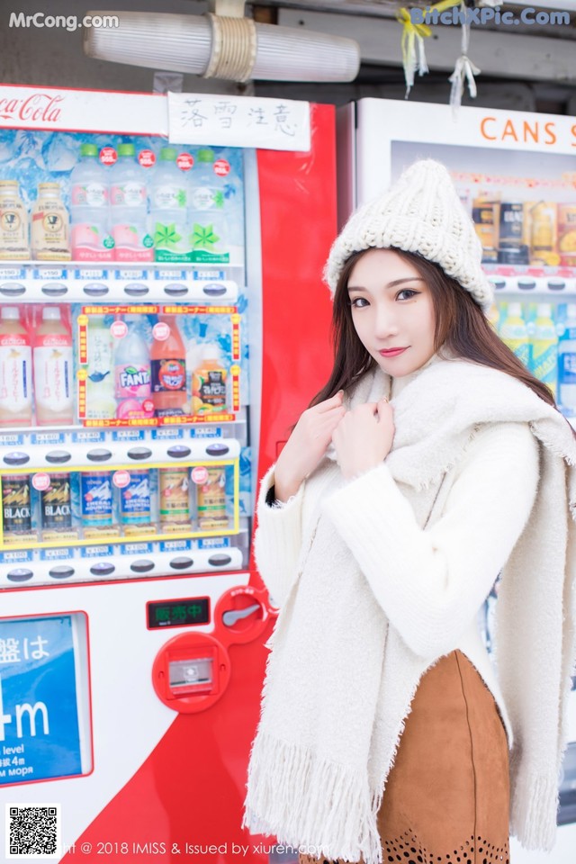 A woman standing in front of a vending machine.