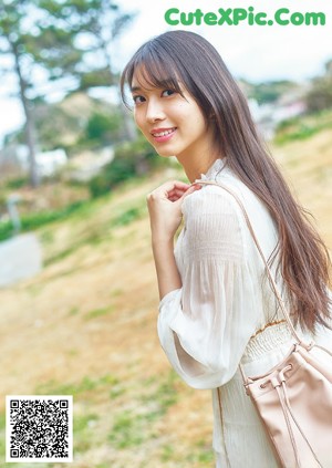 A woman in a blue top is posing for a picture.