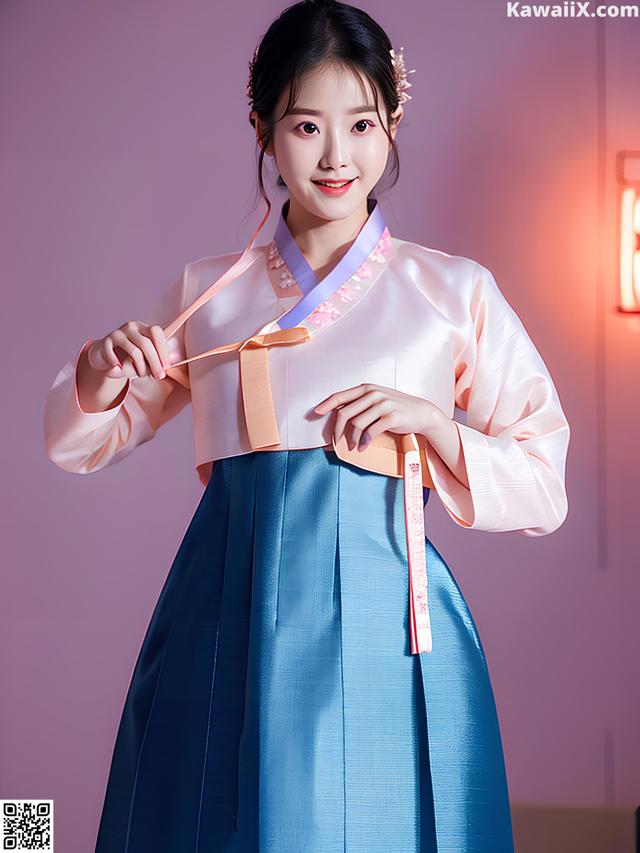 A woman in a blue and pink hanbok is posing for a picture.