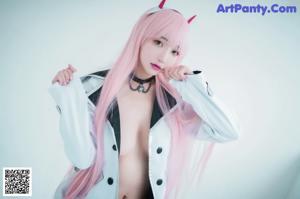A woman with long pink hair wearing a cat ears headband.