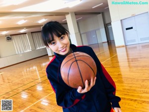 A woman laying on the floor with a basketball on her head.